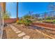 Backyard featuring a stone walking path, green shrubbery, and metal fence at 3685 Australian Cloud Dr, Las Vegas, NV 89135