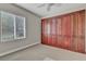 Carpeted bedroom with a large window and a built-in closet system for optimal storage at 3685 Australian Cloud Dr, Las Vegas, NV 89135