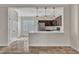 View of the updated kitchen with stainless appliances, wood cabinets, and breakfast bar overlooking living space at 3685 Australian Cloud Dr, Las Vegas, NV 89135