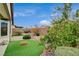 This backyard features desert landscaping, artificial turf, citrus trees, and a covered patio at 3717 Rocklin Peak Ave, North Las Vegas, NV 89081