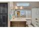 Bathroom with white countertop, dark brown cabinets, and a shower-tub with a glass shower door at 3717 Rocklin Peak Ave, North Las Vegas, NV 89081