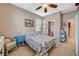 Comfortable bedroom featuring a ceiling fan, a cute bedspread, and a view to the bathroom at 3717 Rocklin Peak Ave, North Las Vegas, NV 89081