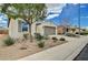 Landscaped yard of home with a two-car garage, desert landscaping and beige stucco at 3717 Rocklin Peak Ave, North Las Vegas, NV 89081