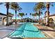 Resort-style pool area surrounded by palm trees and comfortable seating under a bright blue sky at 3717 Rocklin Peak Ave, North Las Vegas, NV 89081
