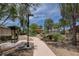 Walk through the park under mature trees on the concrete path surrounded by desert landscaping at 3717 Rocklin Peak Ave, North Las Vegas, NV 89081