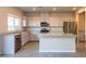 Well-lit kitchen boasts stainless steel appliances, granite countertops, and a central island, offering functionality and style at 480 Silverweed Ave, Henderson, NV 89044