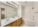 Bright bathroom features a double sink vanity with decorative mirror and combination shower/tub at 51 E Agate Ave # 506, Las Vegas, NV 89123