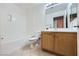 Bright bathroom featuring a vanity with wooden cabinetry and bathtub with tile flooring at 51 E Agate Ave # 506, Las Vegas, NV 89123