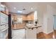 Bright kitchen featuring granite counters, wood cabinets, stainless steel appliances, and a skylight for natural lighting at 51 E Agate Ave # 506, Las Vegas, NV 89123