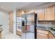 Kitchen featuring wood cabinets, stainless steel appliances, and granite countertops at 51 E Agate Ave # 506, Las Vegas, NV 89123