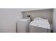 Bright laundry room featuring a white washer and dryer with upper shelving at 5648 Vermillion Ridge St, North Las Vegas, NV 89031