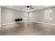 Bright, minimalist bedroom with light gray walls, modern ceiling fan, and wood-look flooring at 5662 Tingley Ave, Las Vegas, NV 89141