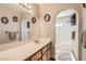 This bathroom features a sink with vanity, large mirror, and tiled shower and flooring at 5775 W Desert Inn Rd, Las Vegas, NV 89146