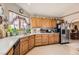 Spacious kitchen with oak cabinets, stainless refrigerator, and tile flooring leading to dining area at 5775 W Desert Inn Rd, Las Vegas, NV 89146
