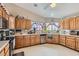 A well-lit kitchen featuring oak cabinets, neutral countertops, and a stainless steel dishwasher at 5775 W Desert Inn Rd, Las Vegas, NV 89146