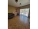 Living room with sliding glass doors, neutral paint, and light tile flooring at 5820 W Desert Inn Rd, Las Vegas, NV 89146