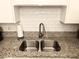 A stainless-steel sink with granite countertop and white tile backsplash at 625 S Royal Crest Cir # 2, Las Vegas, NV 89169