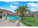 A private backyard with a pool, palm tree, and artificial grass offers a relaxing oasis at 6611 Ellerhurst Dr, Las Vegas, NV 89103