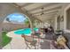 Inviting covered patio with outdoor seating overlooking a pool and landscaped backyard at 6611 Ellerhurst Dr, Las Vegas, NV 89103