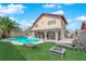 Backyard featuring artificial turf, a covered patio with outdoor seating, and a sparkling swimming pool at 6611 Ellerhurst Dr, Las Vegas, NV 89103