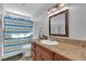 Bright bathroom featuring a granite vanity, wood cabinets, tile flooring and a shower with colorful curtain at 6611 Ellerhurst Dr, Las Vegas, NV 89103