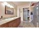 Bright bathroom features a double sink vanity, granite countertops, and gray closet with mirrors at 6611 Ellerhurst Dr, Las Vegas, NV 89103