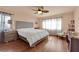 Cozy bedroom featuring hardwood floors, a ceiling fan, and a bed with white comforter by a window with curtains at 6611 Ellerhurst Dr, Las Vegas, NV 89103