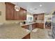Well-lit kitchen with granite countertops, wood cabinets and stainless steel dishwasher at 6611 Ellerhurst Dr, Las Vegas, NV 89103