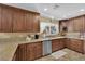 Bright kitchen featuring wood cabinets, granite countertops and stainless steel dishwasher at 6611 Ellerhurst Dr, Las Vegas, NV 89103