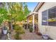 Charming backyard with landscaped gravel, mature trees, and a covered patio area at 7172 Painted Paradise St, Las Vegas, NV 89131
