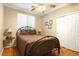 This bedroom boasts an iron bed frame, two side tables with lamps, a ceiling fan, and a closet for storage at 7172 Painted Paradise St, Las Vegas, NV 89131