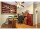 This office features beautiful wood floors, built-in shelving, a ceiling fan, and a built-in desk with cabinets and drawers at 7172 Painted Paradise St, Las Vegas, NV 89131