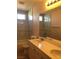 Bathroom with marble style walls, double vanity sink, large mirror, shower, and bath at 8122 Delphi Ct, Las Vegas, NV 89117