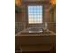Bright bathroom featuring a soaking tub, marble countertops, and large window at 8122 Delphi Ct, Las Vegas, NV 89117