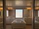 Bright bathroom featuring a soaking tub, marble countertops, and large mirrored vanities at 8122 Delphi Ct, Las Vegas, NV 89117