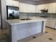 Kitchen with white cabinets, gray tile backsplash and large island with quartz countertop at 8122 Delphi Ct, Las Vegas, NV 89117