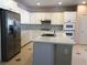 Bright kitchen with white cabinets, gray backsplash, stainless steel appliances, and island at 8122 Delphi Ct, Las Vegas, NV 89117