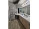 Bathroom featuring double sinks, bright vanity lighting, gray walls, and plenty of counter space and mirrors at 824 Holly Lake Way, Henderson, NV 89002