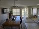 Dining area with a wooden table set near a window, stylish lighting, and glass doors leading to the outside at 824 Holly Lake Way, Henderson, NV 89002