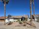 Charming single-story home featuring a two-car garage, desert landscaping, and mature trees at 824 Holly Lake Way, Henderson, NV 89002