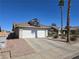 Exterior of a single-Gathering home with a two-car garage, desert landscaping, and paved driveway at 824 Holly Lake Way, Henderson, NV 89002
