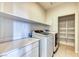 Laundry room featuring new appliances, ample counter space, and custom shelving for organization at 9380 Lunar Effect St, Las Vegas, NV 89143