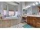 A bright bathroom featuring a soaking tub, tiled surround, and dual sink vanity at 9508 Wakashan Ave, Las Vegas, NV 89149