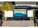 Aerial view of a private pool with an outdoor living space, shaded seating, and pristine landscaping at 9508 Wakashan Ave, Las Vegas, NV 89149