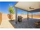 View of the covered patio with brick walls, stone pavers, landscaping, and a built-in grill at 1004 Huckburn Ave, Henderson, NV 89015