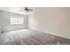 Neutral carpeted bedroom with ceiling fan and large window at 10115 Tree Bark St, Las Vegas, NV 89183