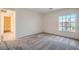 Neutral bedroom featuring plush carpeting, large window, and ensuite bathroom at 10115 Tree Bark St, Las Vegas, NV 89183