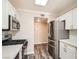 Well-lit kitchen with stainless steel appliances, white cabinets and wood flooring at 10115 Tree Bark St, Las Vegas, NV 89183