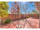 Red stamped concrete patio in backyard with mature trees, plants, a gazebo, and surrounding brick walls at 10490 Palmadora St, Las Vegas, NV 89178