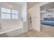 Bright bathroom featuring a tub, stand-up shower, and view into the bedroom at 10490 Palmadora St, Las Vegas, NV 89178